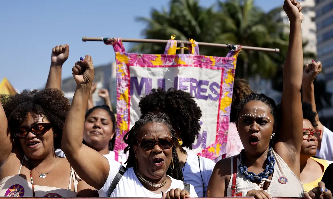 Imagem de mulheres felizes em uma passeata sobre direito das mulheres