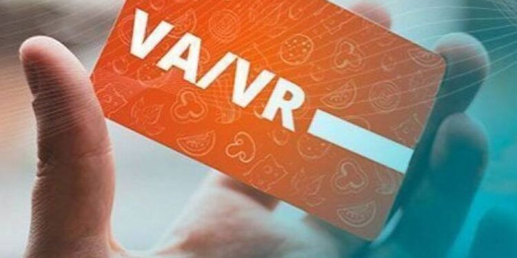 Imagem de um cartão de Vale-Alimentação sendo segurado por uma mão, com destaque para a inscrição 'VA/VR'.