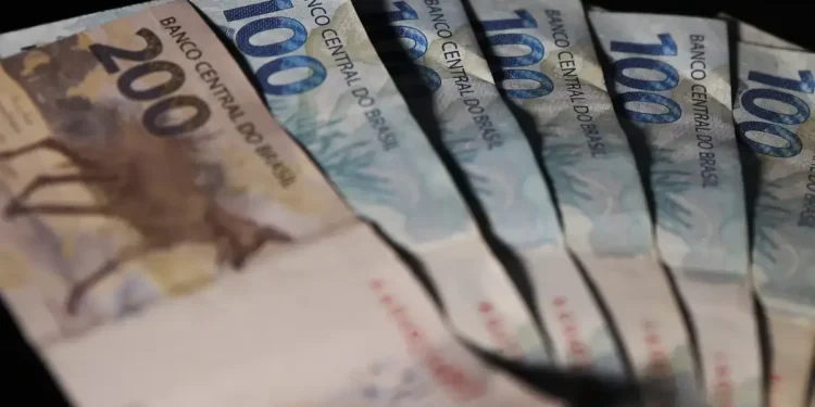 Cédulas de 100 e 200 reais representando valores a serem sacados do Fundo PIS/Pasep