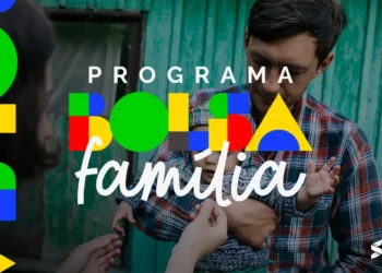 Família recebendo o benefício do Bolsa Família, com cédulas de 100 reais em mãos, simbolizando o pagamento do benefício