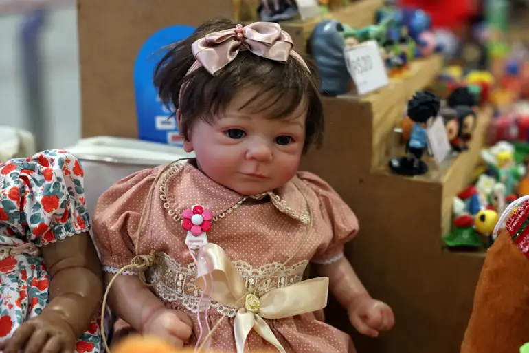 boneca bebe reborn vestida de rosa exposta em feira de brinquedos