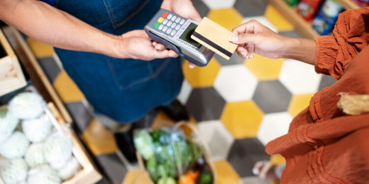 Imagem de transação com cartão de pagamento, representando o uso do Vale-alimentação no comércio.