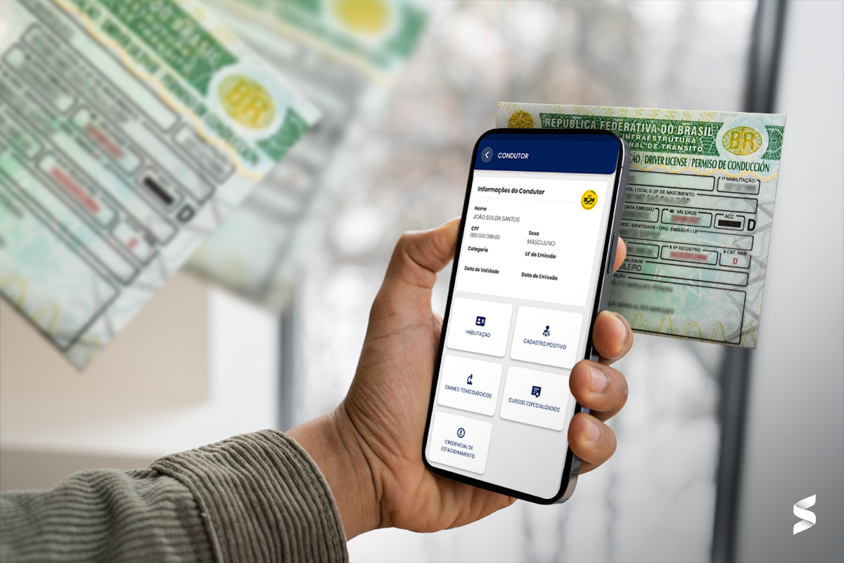 Mão segurando smartphone com app da CNH digital aberto, com carteira física ao fundo