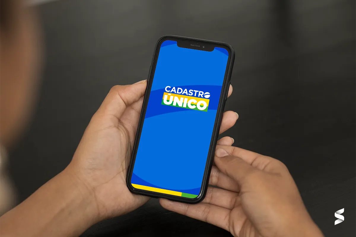 Pessoa segurando celular exibindo a tela com o logo do Cadastro Único.