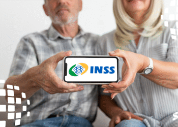 Casal com celular exibindo o logo do Meu INSS, mostrando como acessar facilmente os serviços online da Previdência Social.