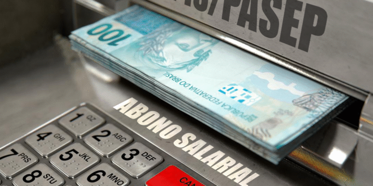 Notas de 100 reais sendo retiradas de um caixa eletrônico com teclado, com as palavras "PIS/PASEP" e "Abono Salarial" em destaque.