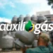 Homem carregando botijão de gás em depósito, com a marca do programa Auxílio Gás sobreposta
