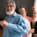 Casal de idosos felizes dançando juntos em casa, celebrando os benefícios exclusivos para idosos em 2025.