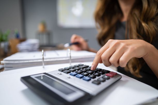 Pessoa usando uma calculadora para realizar cálculos financeiros importantes