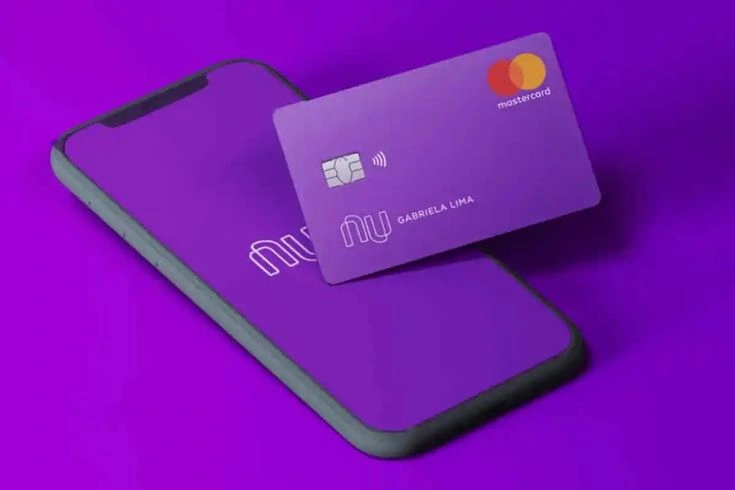 Cartão Nubank roxo sobre celular com tela roxa, simbolizando serviços digitais de banco.