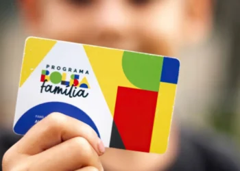 Cartão do Programa Bolsa Família com design colorido segurado por uma criança, ilustrando o benefício social para famílias brasileiras.