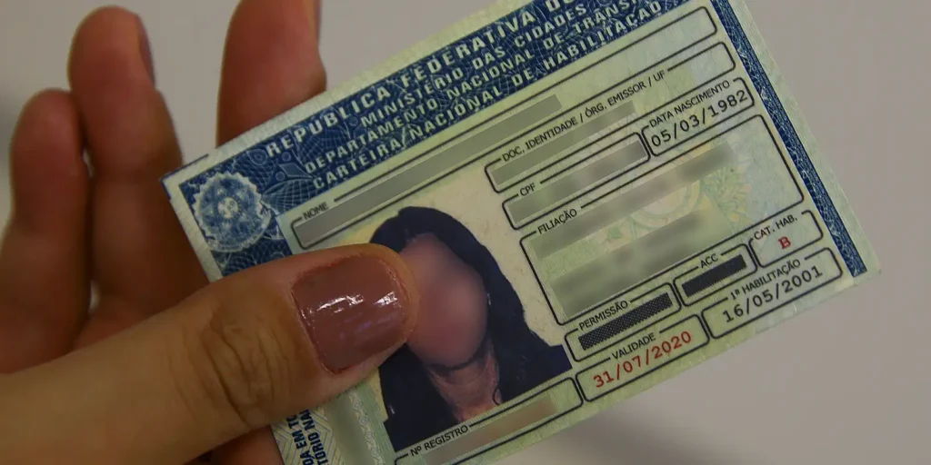 Carteira Nacional de Habilitação (CNH) sendo segurada por uma pessoa, representando oportunidade para vagas gratuitas em 2025.