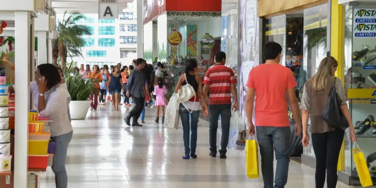 "Pessoas fazendo compras em um shopping, refletindo o aumento das atividades comerciais com a nova legislação sobre trabalho aos domingos e feriados."