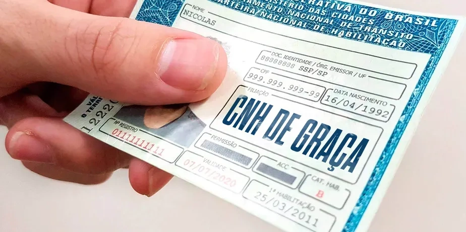 Cartão de CNH Social com dados fictícios mostrando uma mão segurando a carteira.