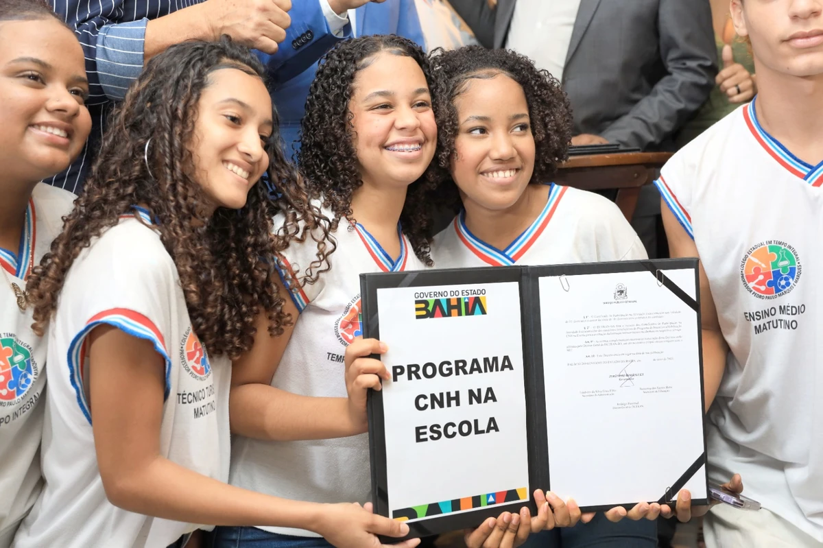 Jovens estudantes segurando documento do Programa CNH na Escola na Bahia, comemorando acesso à CNH gratuita em 2025.