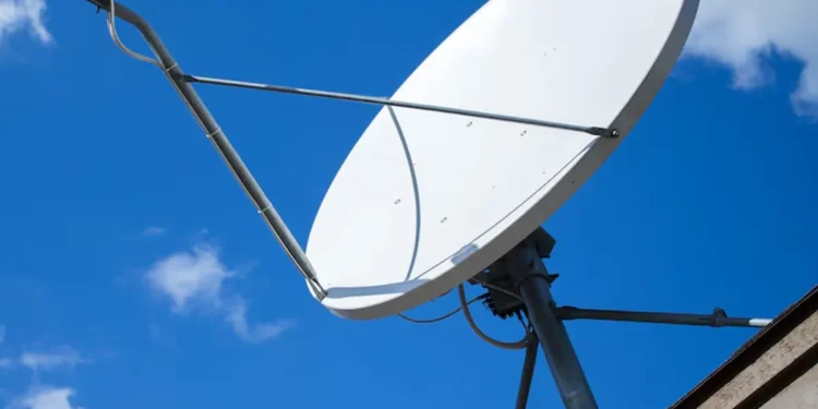Antena parabólica tradicional instalada no telhado sob céu azul