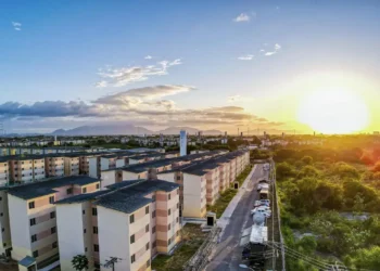Conjunto habitacional do Minha Casa, Minha Vida ao entardecer, simbolizando esperança e dignidade.