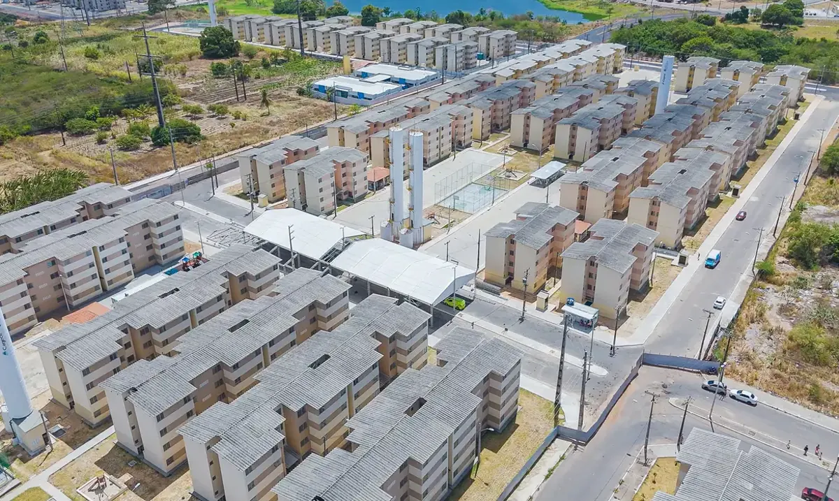 Vista aérea de conjunto habitacional do programa Minha Casa, Minha Vida mostrando várias moradias em construção.