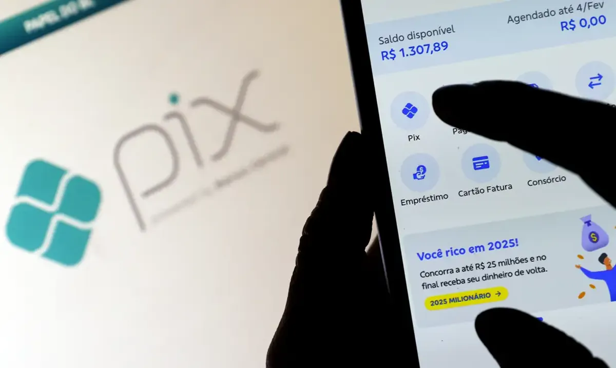 Pessoa usando celular com aplicativo PIX exibindo saldo disponível
