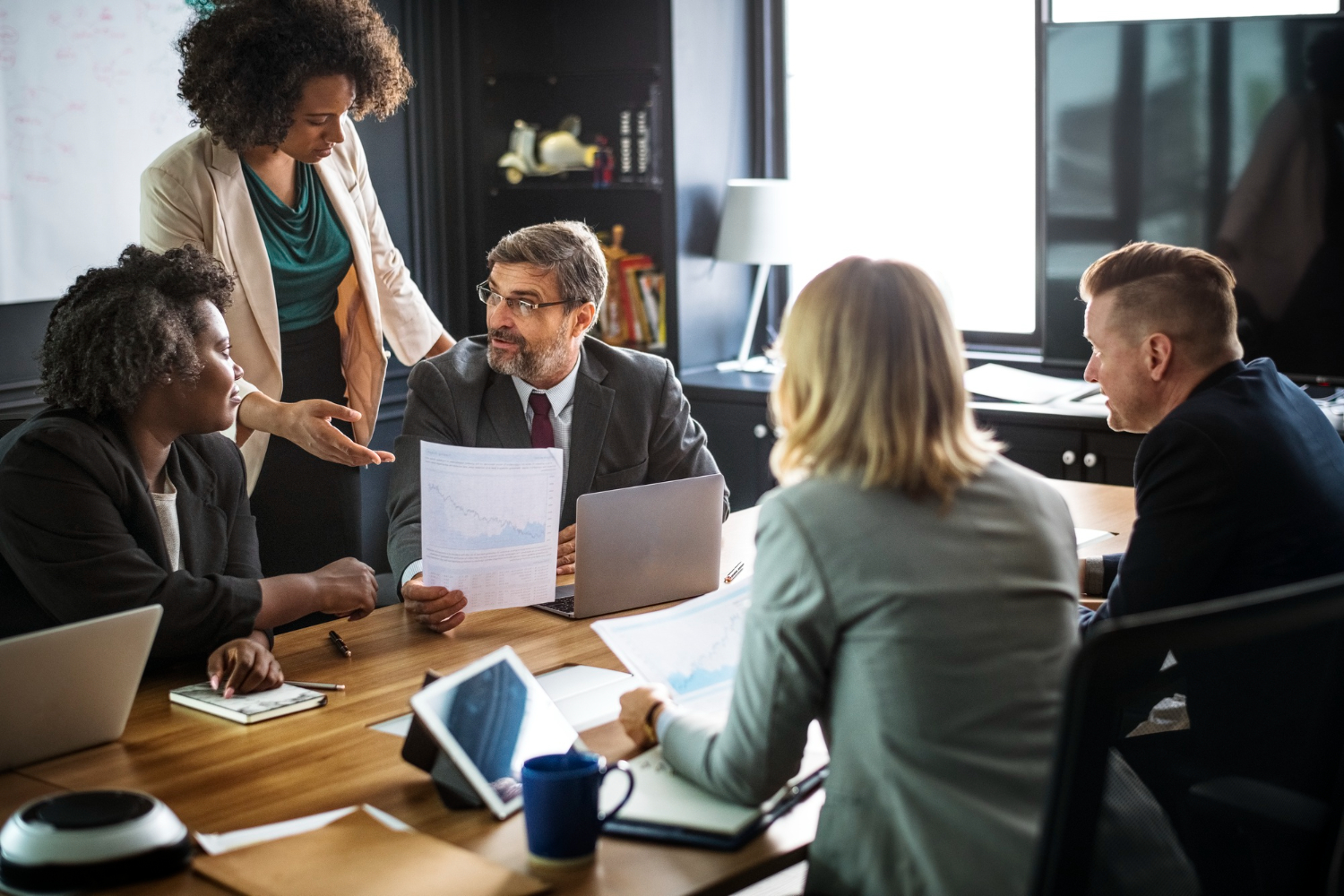 Grupo de pessoas discutindo estratégias em uma reunião, representando a atuação de representantes dos trabalhadores em questões trabalhistas.
