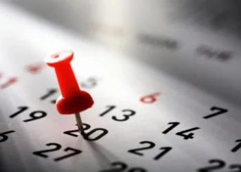 Pin vermelho marcado no dia 20 de um calendário, destacando a importância do 5º dia útil