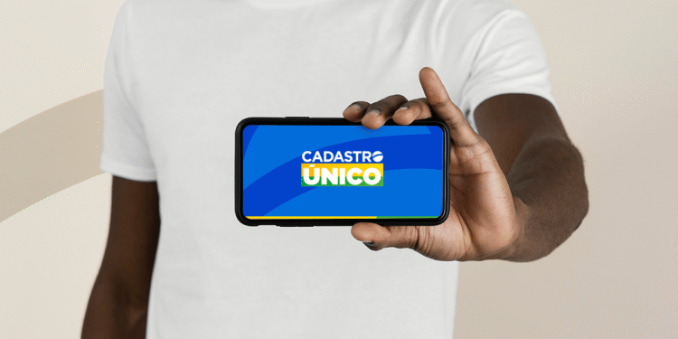 Imagem de celular com logo do Cadastro Único (CadÚnico) na tela, destacando a importância do cadastro para o recebimento de benefícios.