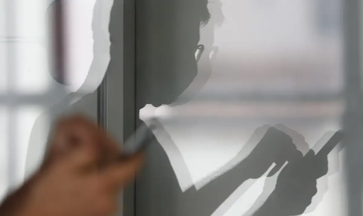 Imagem de uma pessoa com um celular, simbolizando o risco de vazamento de dados e a necessidade de proteção digital.