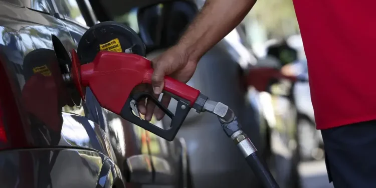 Imagem de um frentista abastecendo um carro com gasolina, simbolizando o impacto da nova composição nos preços dos combustíveis.