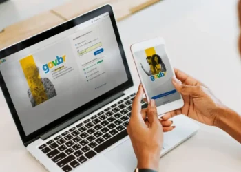 Pessoa acessando a conta gov.br pelo celular e notebook