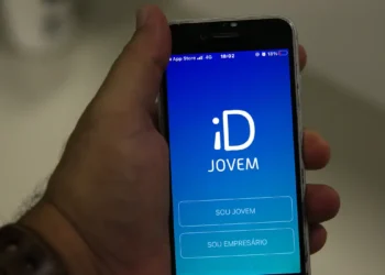 Pessoa segura celular com aplicativo do ID Jovem aberto na tela