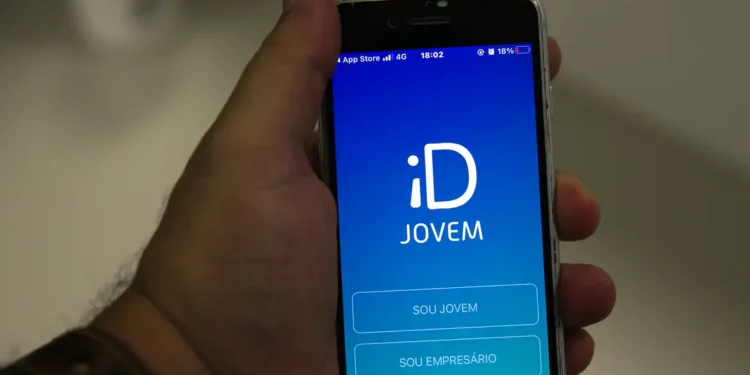 Pessoa segura celular com aplicativo do ID Jovem aberto na tela