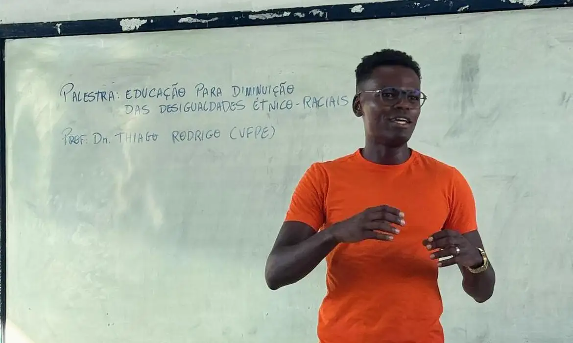 "Professor ministrando palestra sobre a educação para diminuir desigualdades étnico-raciais"