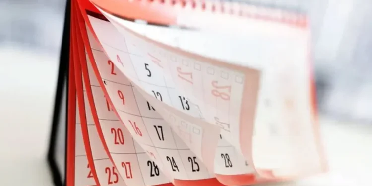 Calendário de mesa com páginas viradas mostrando dias do mês, ênfase no mês de junho com destaque para o dia 12.