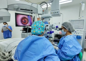 Equipe médica realizando cirurgia de catarata com equipamento especializado em ambiente hospitalar.