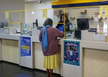 Pessoa sendo atendida nos Correios para consulta sobre cobrança indevida do INSS