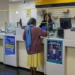 Pessoa sendo atendida nos Correios para consulta sobre cobrança indevida do INSS