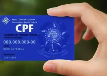 Pessoa segurando cartão azul com número de CPF em destaque