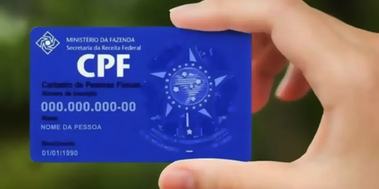 Pessoa segurando cartão azul com número de CPF em destaque