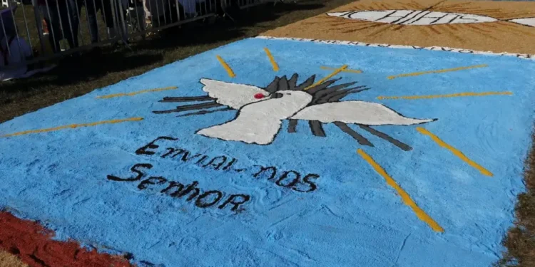 Imagem colorida de um tapete de Corpus Christi, com uma pomba branca em destaque e a inscrição 'Enviados ao Senhor'.