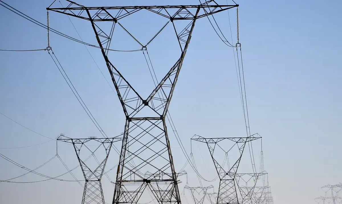 Pilares de uma linha de transmissão de energia elétrica, simbolizando o fornecimento de energia elétrica.