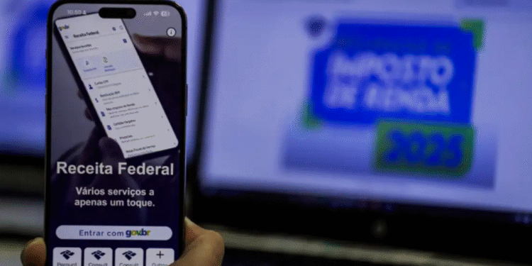 Imagem mostrando um celular com a interface do app Receita Federal e tela de computador com banner sobre Imposto de Renda 2025, alertando sobre golpes relacionados a restituição.