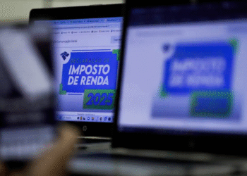 Imagem com computadores exibindo informações sobre a declaração do Imposto de Renda 2025.