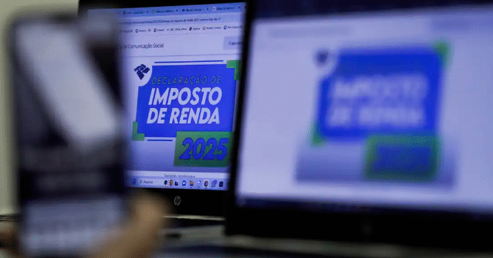 Imagem com computadores exibindo informações sobre a declaração do Imposto de Renda 2025.