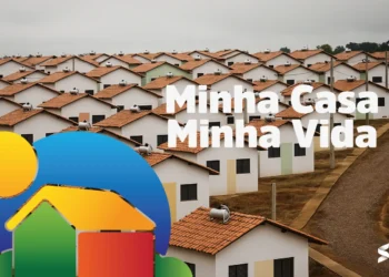 Imagem de conjunto habitacional com casas do programa Minha Casa, Minha Vida, com telhados vermelhos e fundo com céu nublado.
