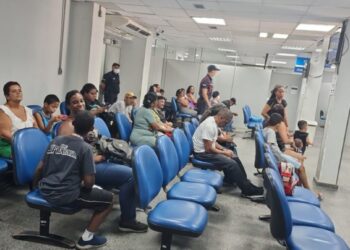 Pessoas aguardam atendimento em unidade do INSS durante mutirão.