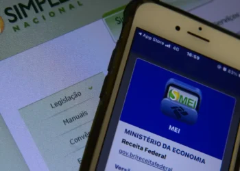 Tela do celular exibindo informações sobre o MEI com site da Receita Federal ao fundo