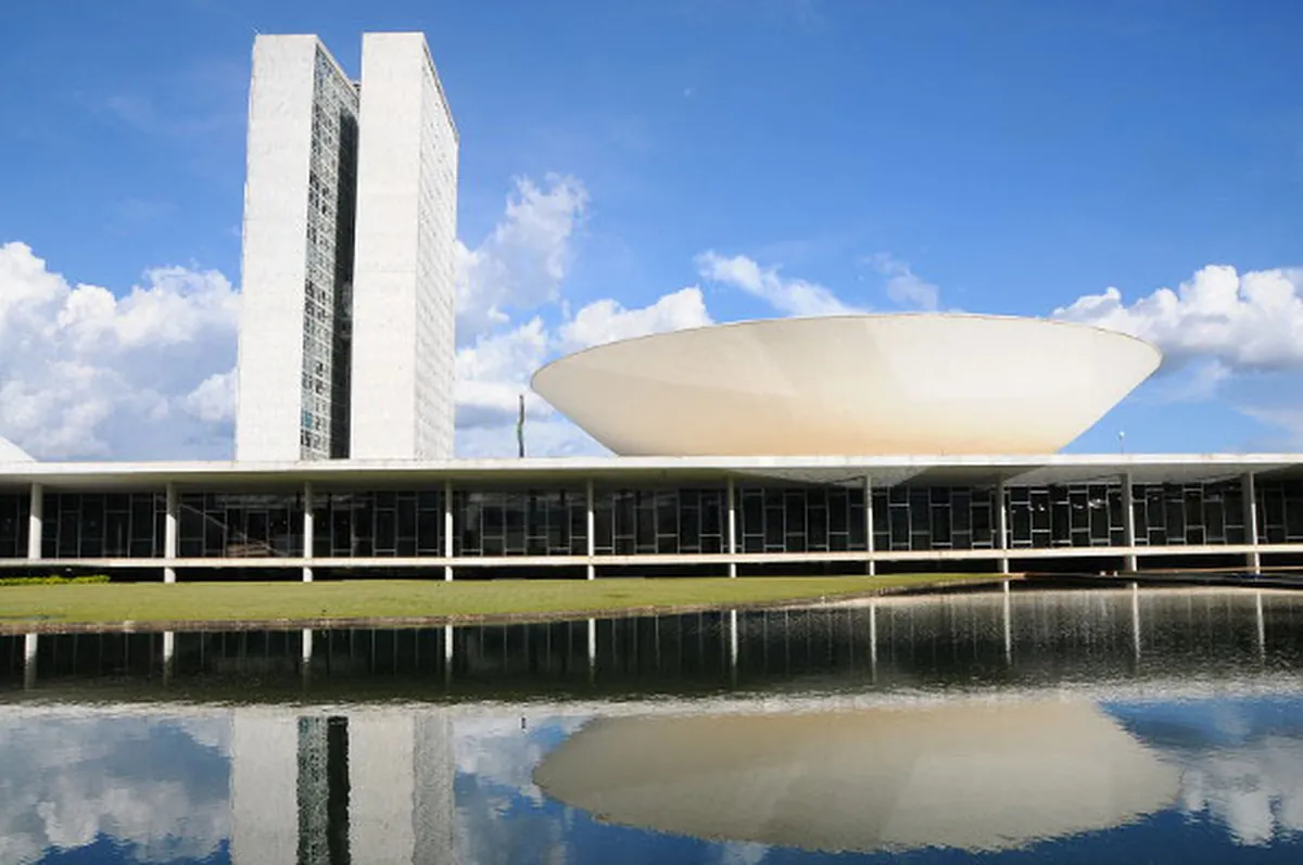 Fachada do Congresso Nacional em Brasília refletida no espelho d’água