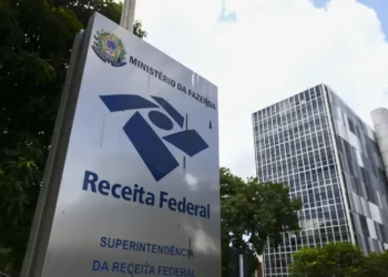 Placa da Receita Federal com o prédio da instituição ao fundo, simbolizando o retorno da entrega das declarações do Imposto de Renda 2025.