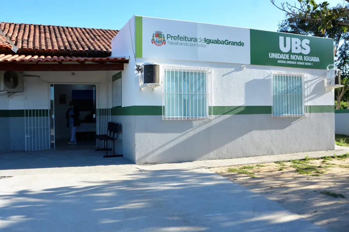 Unidade Básica de Saúde UBS com fachada visível, destacando o local de vacinação e pesagem obrigatória para beneficiários do Bolsa Família.