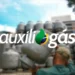 Imagem de um trabalhador com cilindro de gás, com fundo de pilha de botijões e logo do Auxílio-Gás.